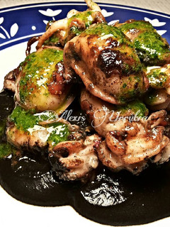 Una foto de Choquitos a la plancha en su tinta, con aceite de ajo y perejil