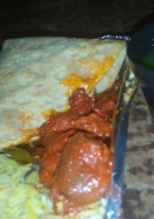 A picture of Basmati rice with tamisa bread and meat souce.