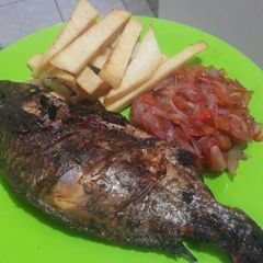 A picture of Roasted fish with yam chips and onion sauce.