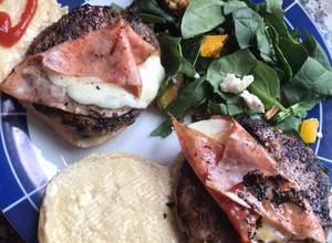 Una foto de Hamburguesas de cordero al yogurt, con ensalada de espinacas y queso por todos lados