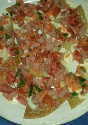 A picture of Nachos with Mexican Salsa and Sausage.
