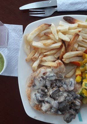 Una foto de Pollo en salsa de champiñones con ensalada de frutas