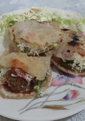 A picture of Pita bread with falafel and tahini sauce.