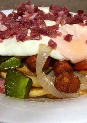 Foto principal de Cama de patatas fritas con verduras, chorizo y huevo frito con jamón
