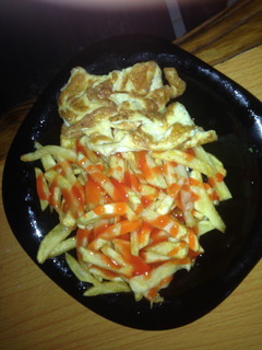 A picture of French fries/ chips with omelette.