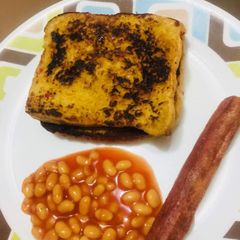 A picture of French Toast with baked beans and Sausage.