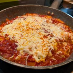 A picture of Italian-Style Shakshuka with Bell Peppers and Cheese.