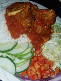 A picture of Rice and stew with cabbage salad.