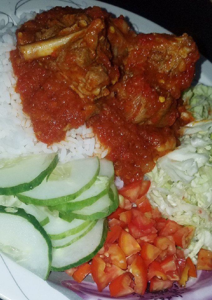 A picture of Rice and stew with cabbage salad.