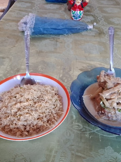 Una foto de Pollo en salsa oscura, acompañado de arroz dulce