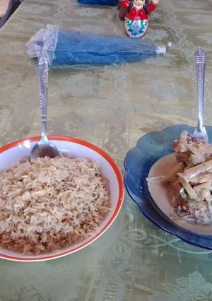 Una foto de Pollo en salsa oscura, acompañado de arroz dulce
