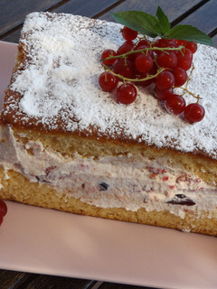 Una foto de Pastel de bizcocho con relleno de crema de bayas rojas