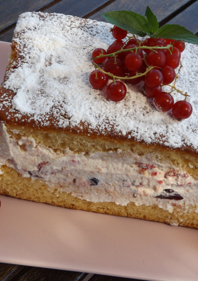 Una foto de Pastel de bizcocho con relleno de crema de bayas rojas