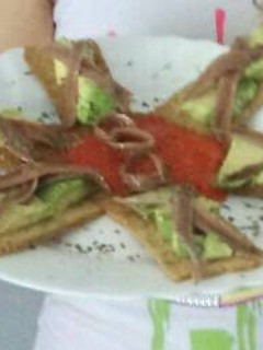 Una foto de Tostas de aguacate con anchoas con un toque de albahaca