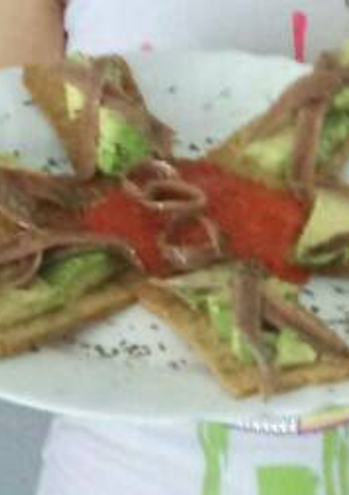 Una foto de Tostas de aguacate con anchoas con un toque de albahaca
