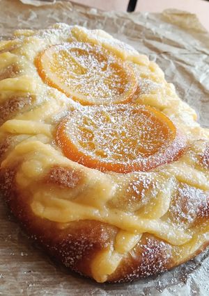 Una foto de Coca Sant Joan 2026 v1: Brioche relleno de cabello de ángel con crema y naranja confitada