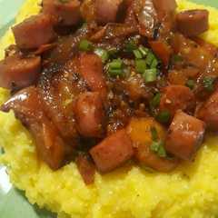 Una foto de Polenta con salsa de tomates asados y salchichas