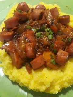Una foto de Polenta con salsa de tomates asados y salchichas