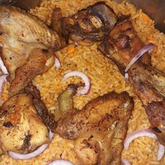 A picture of Jollof rice with fried chicken.