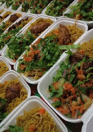 A picture of Party jollof rice with hot n spiced chicken and season salad.