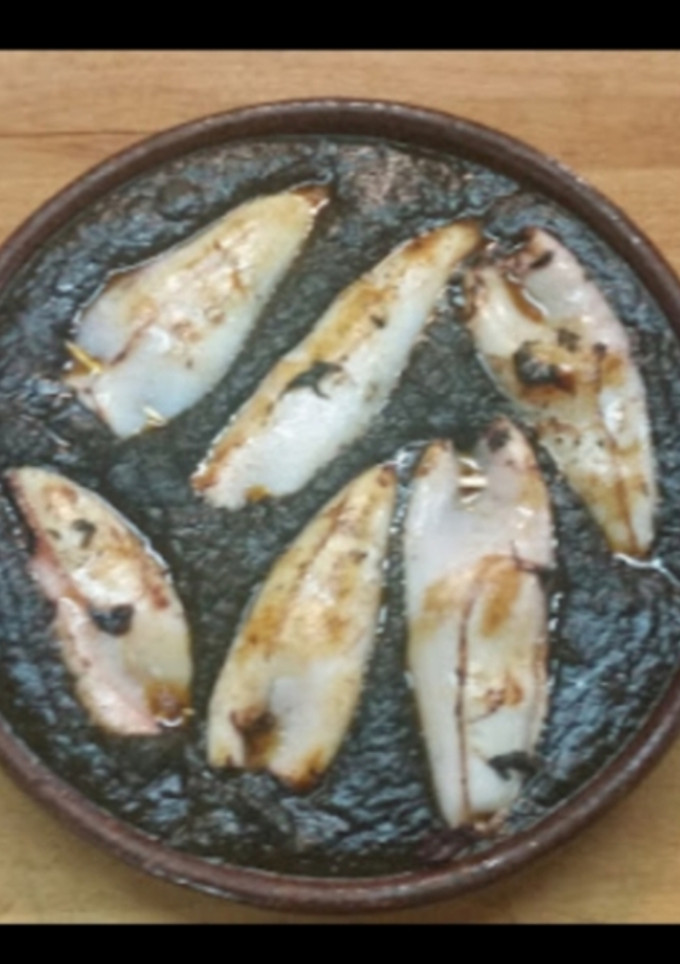 Una foto de Txipirones a la plancha en su tinta