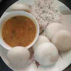 A picture of Sambar with idli or rice.