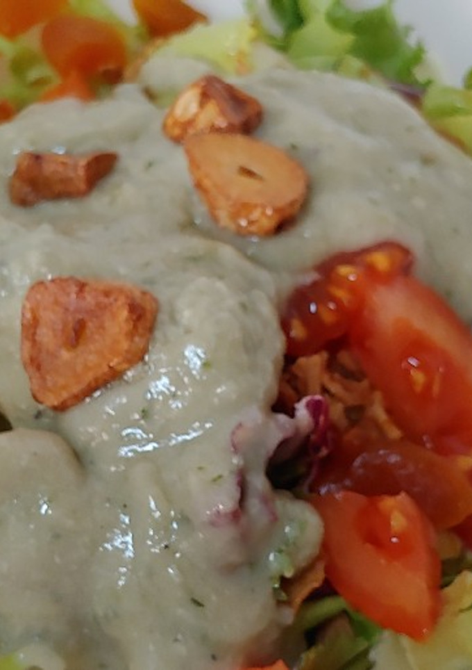 Una foto de Ensalada cabrales, ajos fritos, tomate, con brotes frescos
