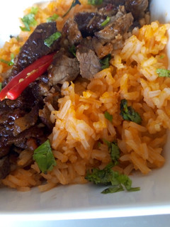 A picture of Mexican rice with Mexican beef.