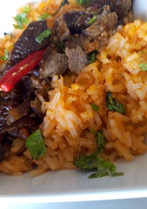 A picture of Mexican rice with Mexican beef.