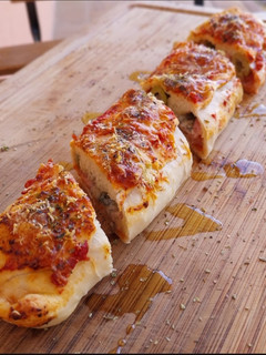 Una foto de Rulo de pizza de jamón, quesos y olivas