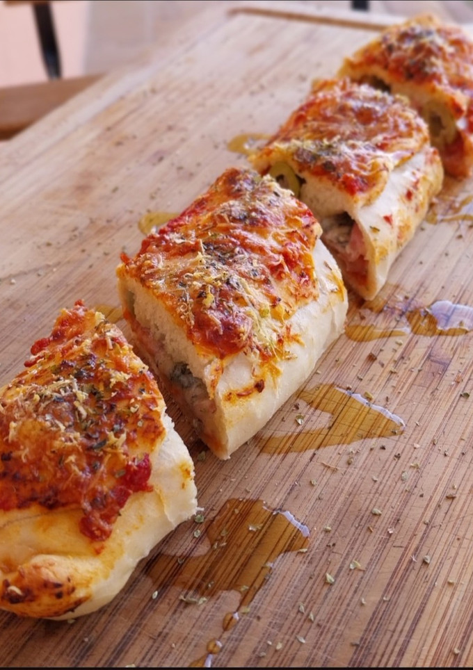 Una foto de Rulo de pizza de jamón, quesos y olivas