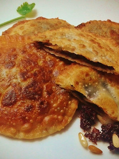 Una foto de Empanadillas de morcilla y queso de cabra, con miel y piñones