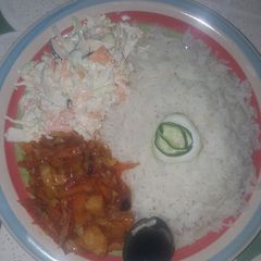 A picture of Rice and stew with coleslow.