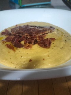 Una foto de Crema de berenjena con topping de jamón serrano y queso