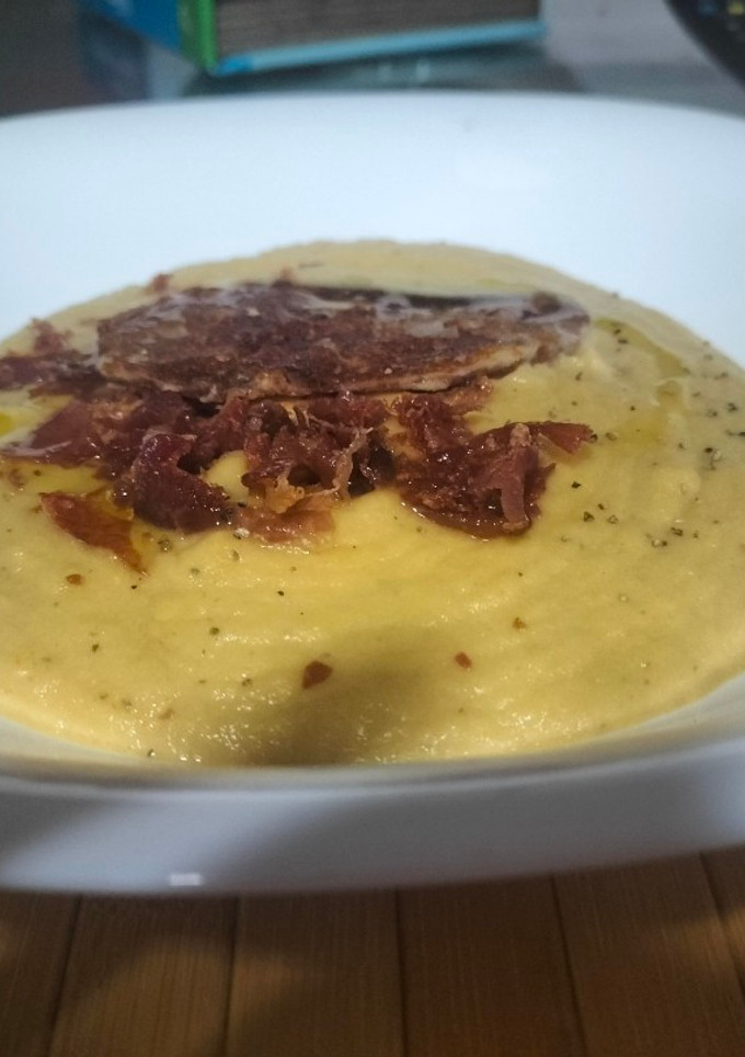 Una foto de Crema de berenjena con topping de jamón serrano y queso
