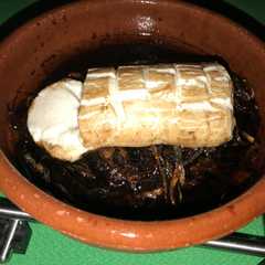 Una foto de Rulo de queso de Cabra sobre cebolla caramelizada y vinagre balsámico al horno