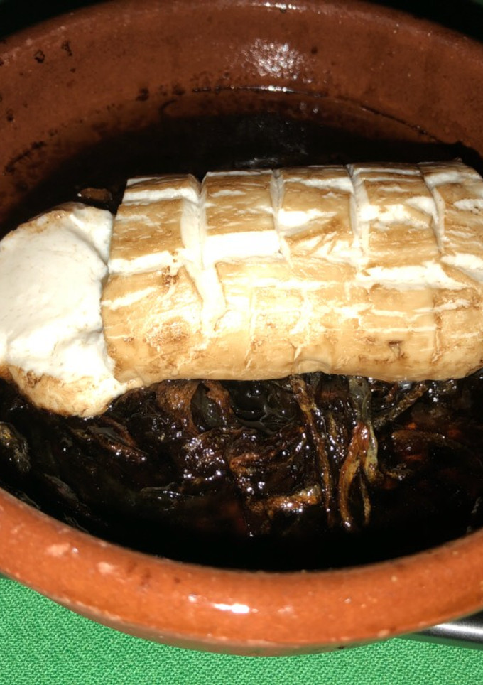Una foto de Rulo de queso de Cabra sobre cebolla caramelizada y vinagre balsámico al horno