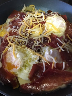 Una foto de Huevos rotos con patatas, pimientos y jamón