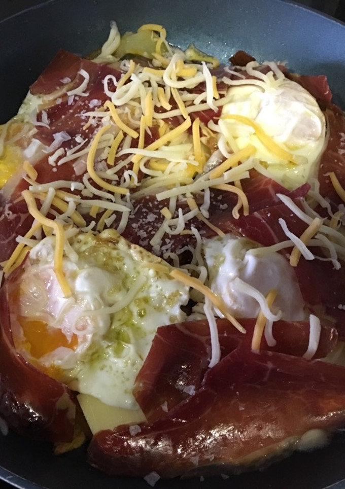 Una foto de Huevos rotos con patatas, pimientos y jamón