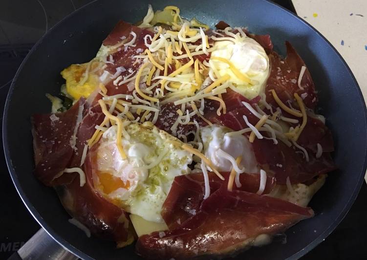 Huevos rotos con patatas, pimientos y jamón