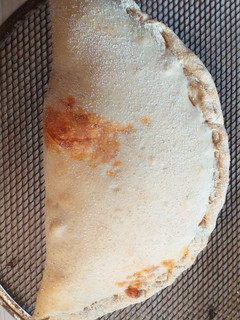 Una foto de Calzone con salsa de tomate