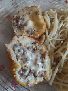 Una foto de Bombas de papas rellenas con picada y queso. Con fideo al pesto