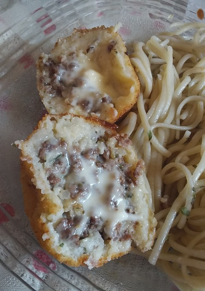 Una foto de Bombas de papas rellenas con picada y queso. Con fideo al pesto