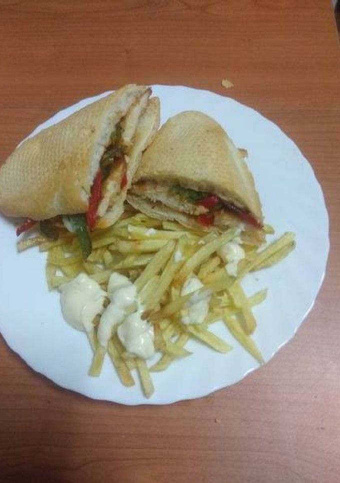Una foto de Bocadillo de pechuga frita con pimiento, queso y papas fritas