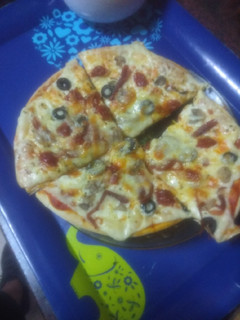 Una foto de Pizza con champiñones, chistorra y aceitunas negras