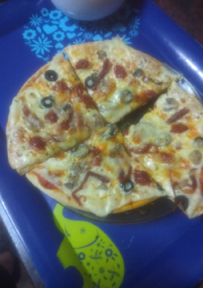 Una foto de Pizza con champiñones, chistorra y aceitunas negras