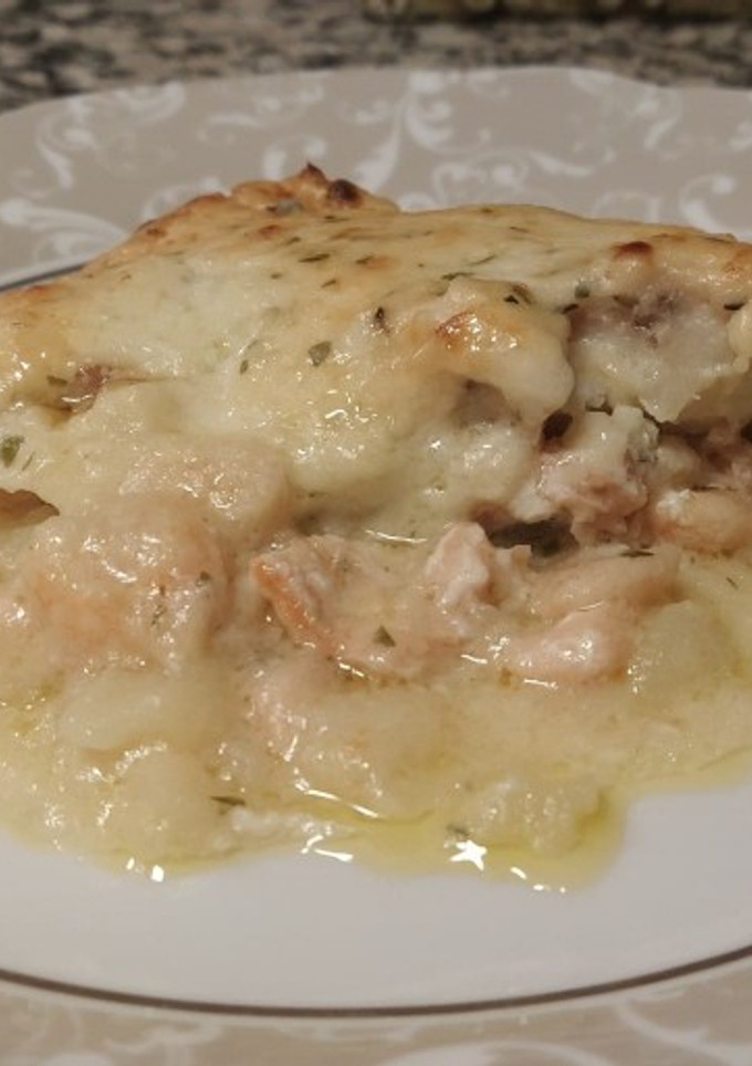 Una foto de Merluza al horno con salmón ahumado, gambas y patatas