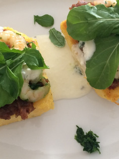 Una foto de Camarones sobre polenta grillada con puré de dátiles y reducción de queso
