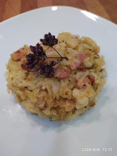 Una foto de Col salteada con bacon, escalonia, ajo, tomate cherry y orégano