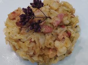 Una foto de Col salteada con bacon, escalonia, ajo, tomate cherry y orégano